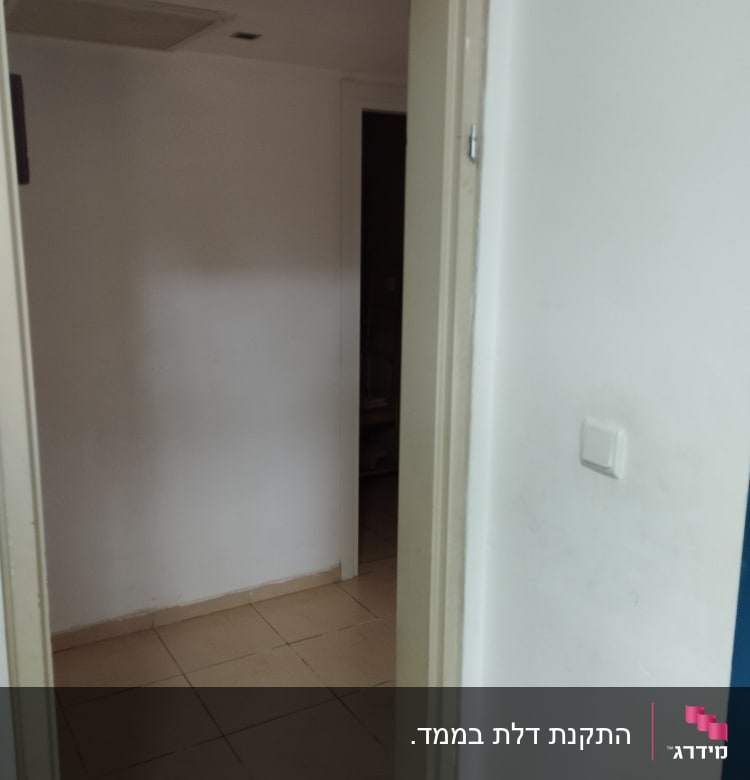 דלת פתוחה עם משקוף בהיר וקיר לבן